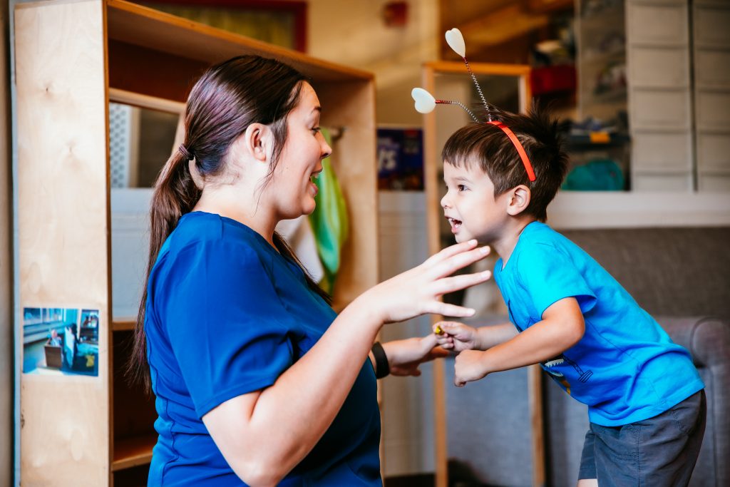 A woman interacts with a young boy at an early childhood education center.