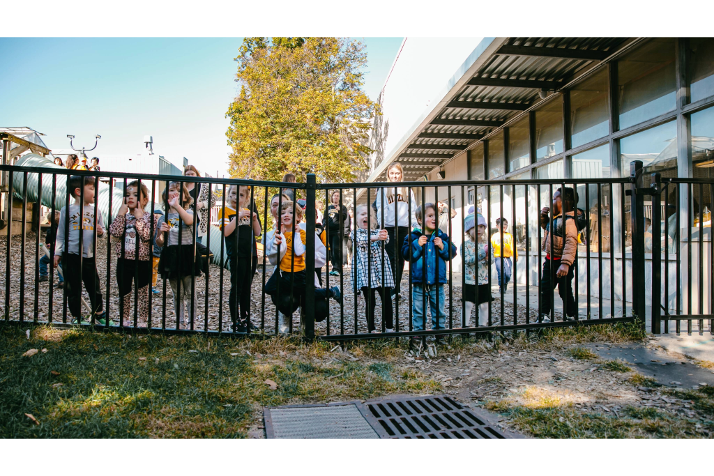Young children stand on a bridge at an early childhood education center playground.