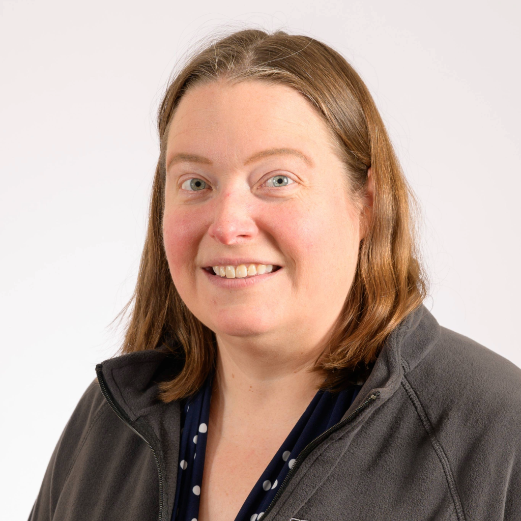 A woman with short brown hair smiling.